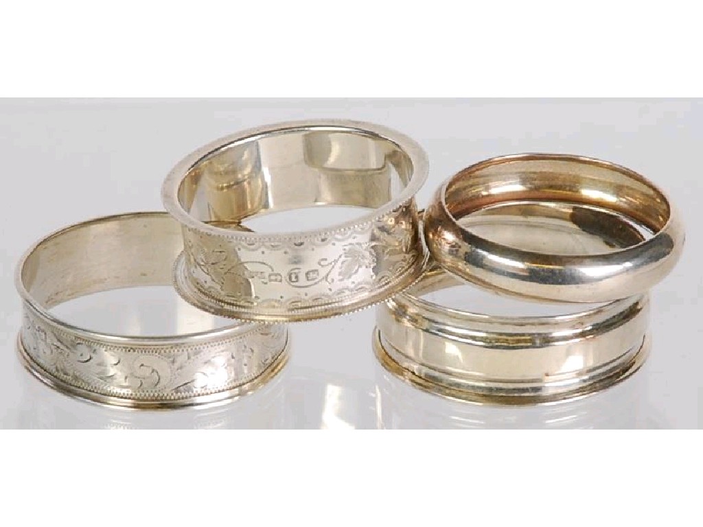 Appraisal: FOUR NARROW SILVER NAPKIN RINGS comprising TWO FLORAL ENGRAVED EXAMPLES