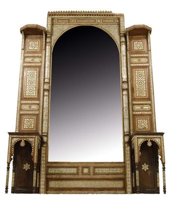 Appraisal: A large Moorish walnut wall mirror the arched bevelled plate