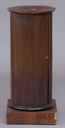 Appraisal: REGENCY MAHOGANY PEDESTAL CUPBOARD The -veneered circular top on reeded