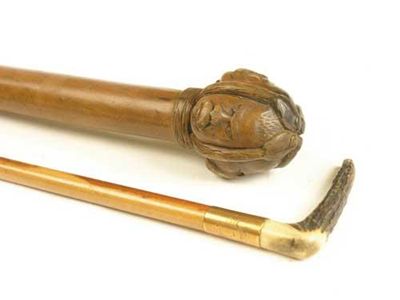 Appraisal: A wood cane with a carved handle depicting four heads