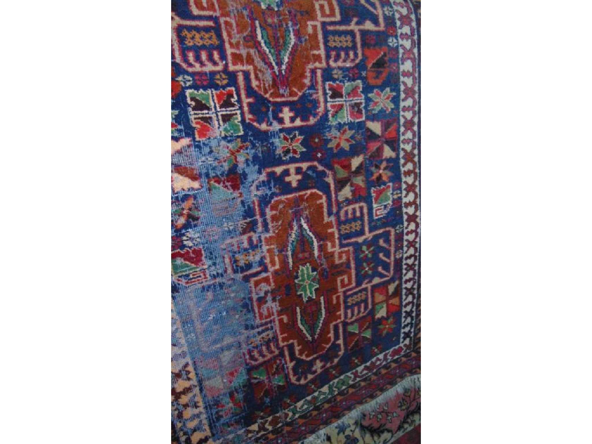 Appraisal: An eastern wool work rug with brightly coloured geometric medallion