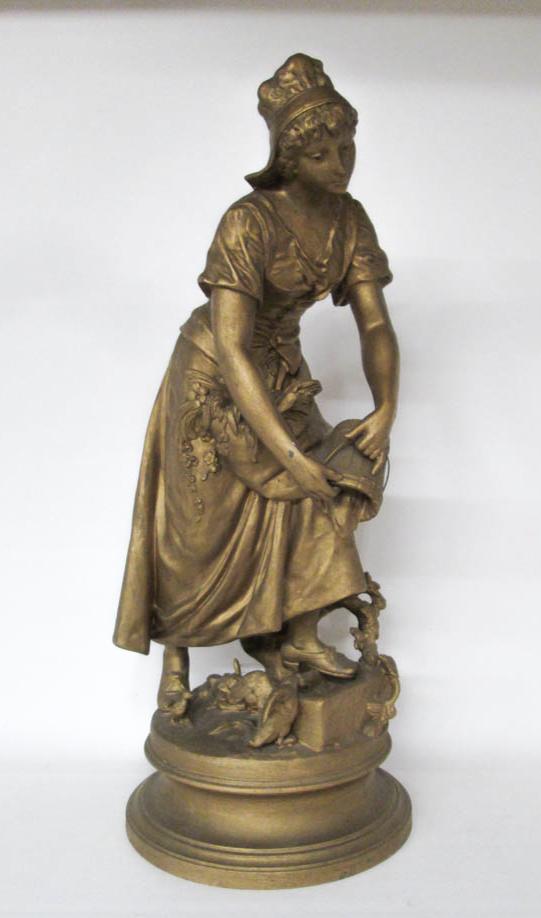 Appraisal: GILT SPELTER FIGURAL SCULPTURE depicting a Dutch woman tending to