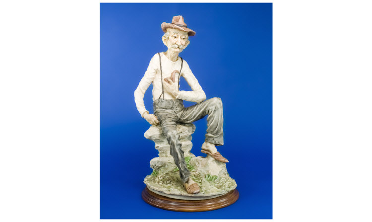 Appraisal: Capodimonte Figure elderly gentleman sitting on a rock inches in