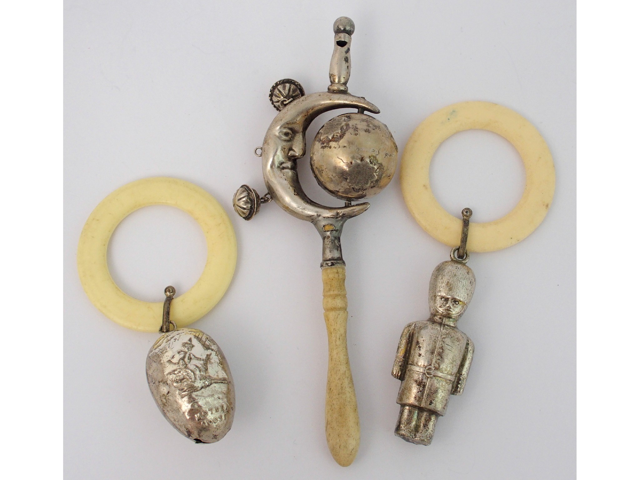 Appraisal: A white metal and bone baby rattle The Man in