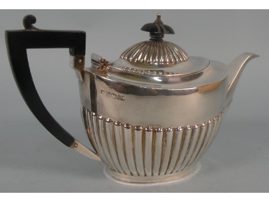 Appraisal: A silver part fluted tea pot with an ebonised knob