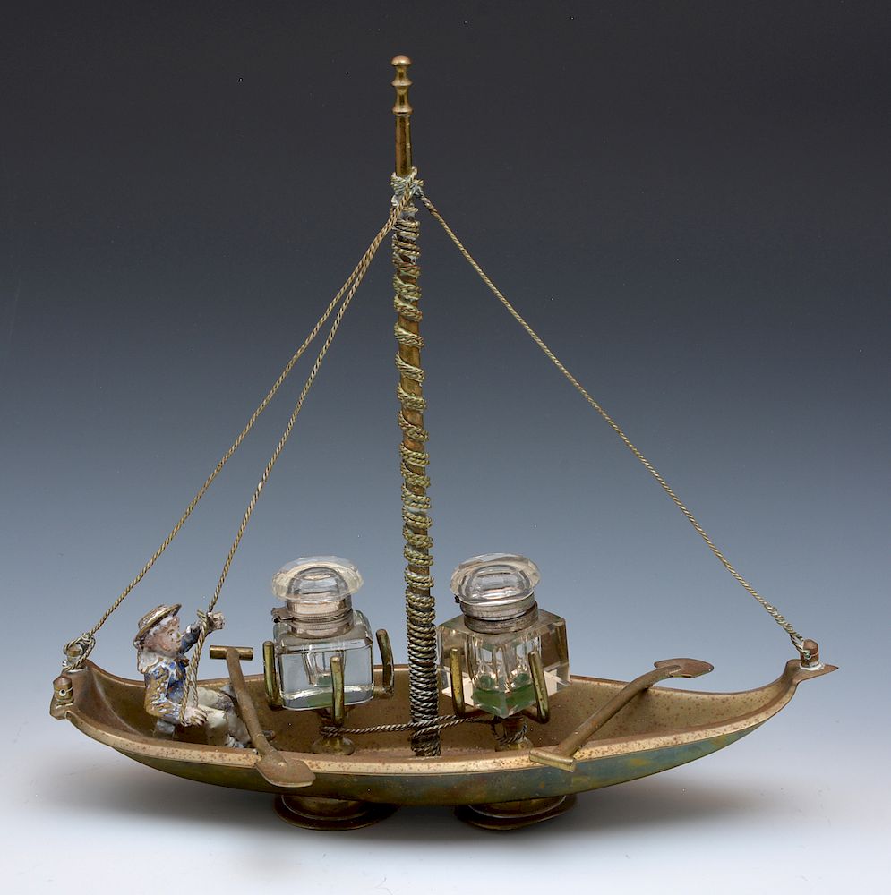 Appraisal: Inkwell set in figural brass boat with painted sailor Inkwell