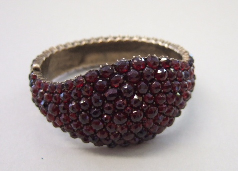 Appraisal: A Bohemian garnet set oval hinged bangle pave set with