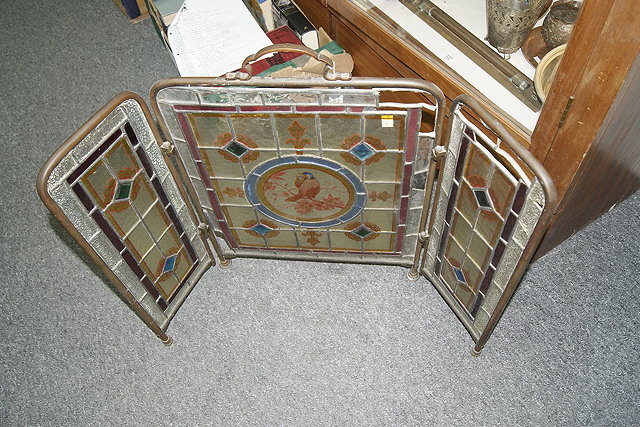 Appraisal: A VICTORIAN STAINED GLASS FOLDING BRASS FIRESCREEN cm across