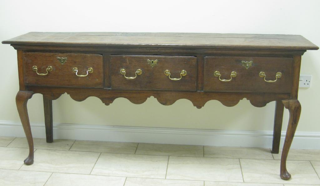 Appraisal: An antique oak Dresser Base fitted three drawers with shaped