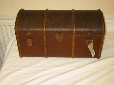 Appraisal: A dolls trunk in canvas covered wood with domed top