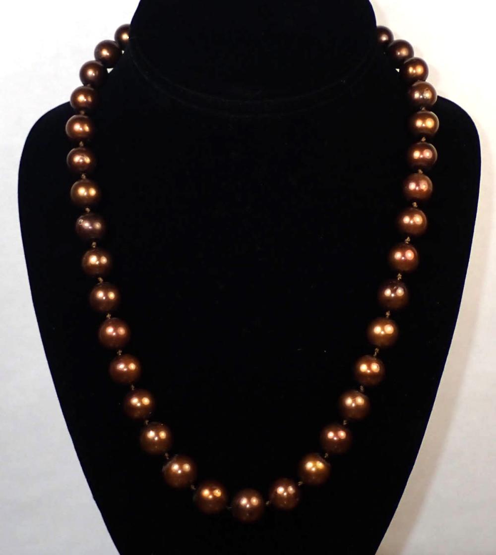 Appraisal: CHOCOLATE PEARL AND FOURTEEN KARAT GOLD NECKLACE The hand-knotted strand