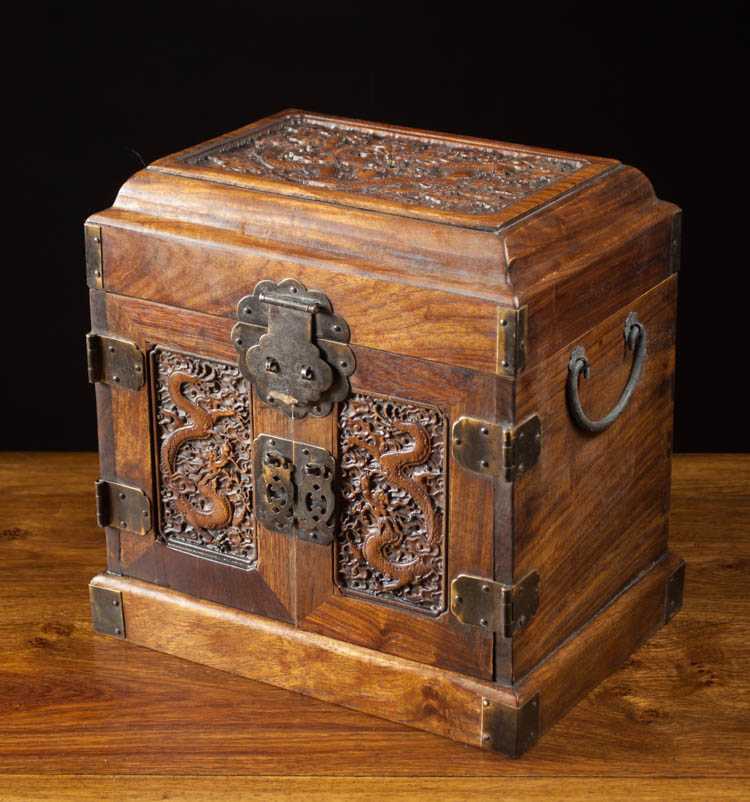 Appraisal: CARVED HUALI WOOD VALUABLES BOX having hinged lid double doors