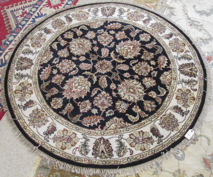 Appraisal: ROUND ORIENTAL AREA RUG Indo-Persian floral pattern on black ground