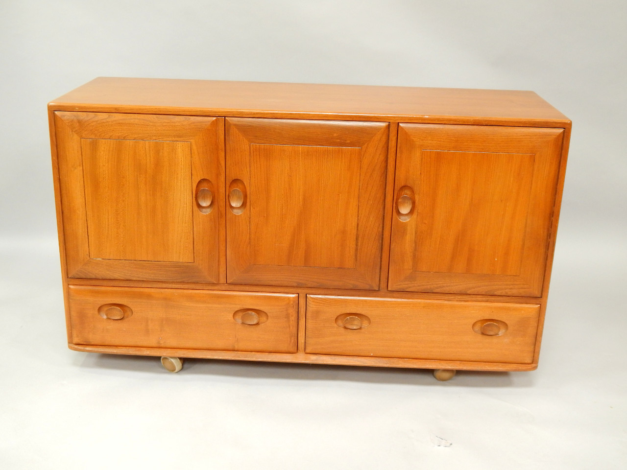 Appraisal: An Ercol oak sideboard with three drawers over two drawers