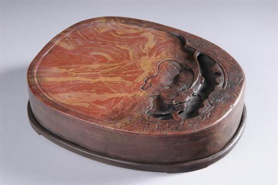 Appraisal: CHINESE VARIEGATED RED INKSTONE Carved in high relief with qilin