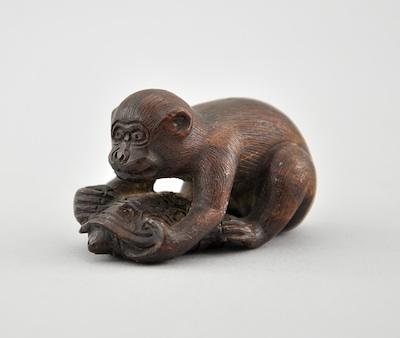 Appraisal: Monkey Playing with Tortoise Wood Netsuke Depicting a monkey playing