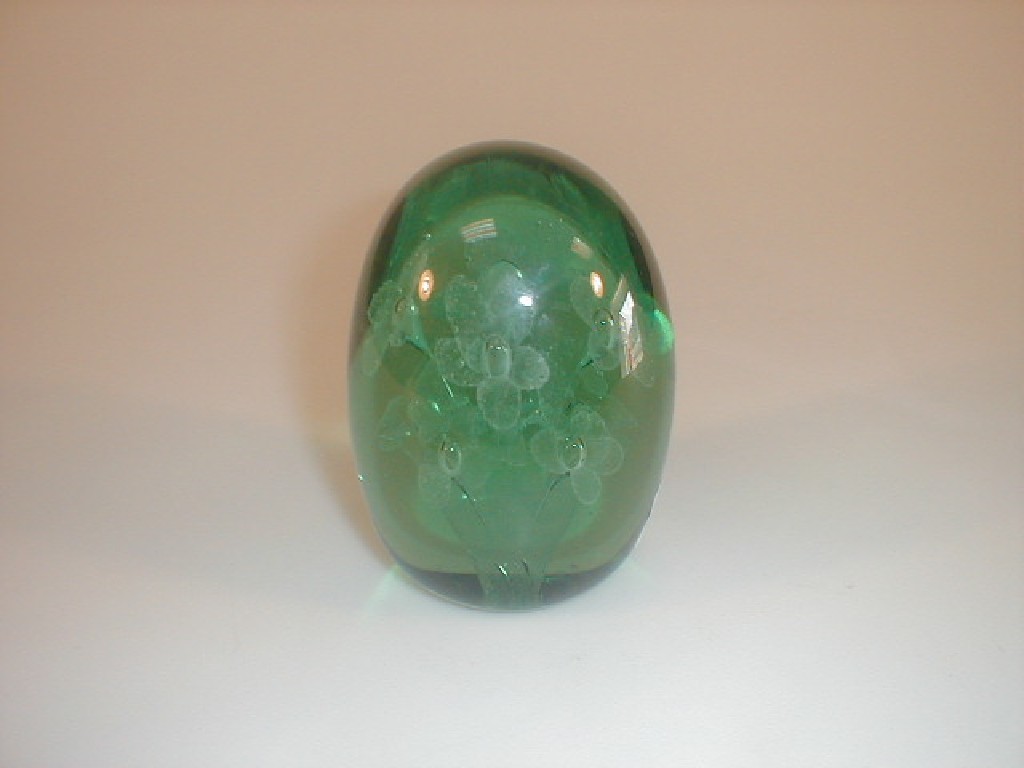 Appraisal: A thC green glass dump internally decorated with a vase