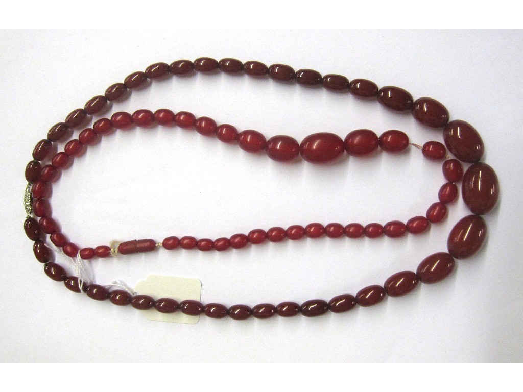 Appraisal: String of red amber beads Approx cm and a string