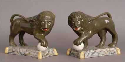 Appraisal: PAIR OF STAFFORDSHIRE GREEN-GLAZED FIGURES OF LIONS Each modeled with