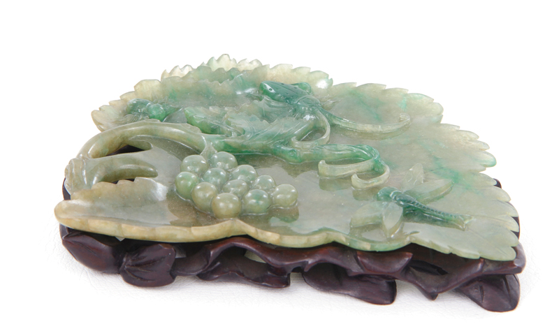 Appraisal: Chinese translucent carved jade grape-leaf with insects Qing dynasty grape