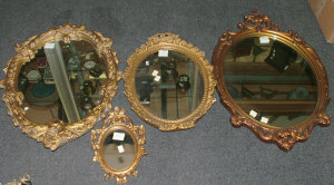 Appraisal: An oval wall mirror in a scroll decorated gilt composition