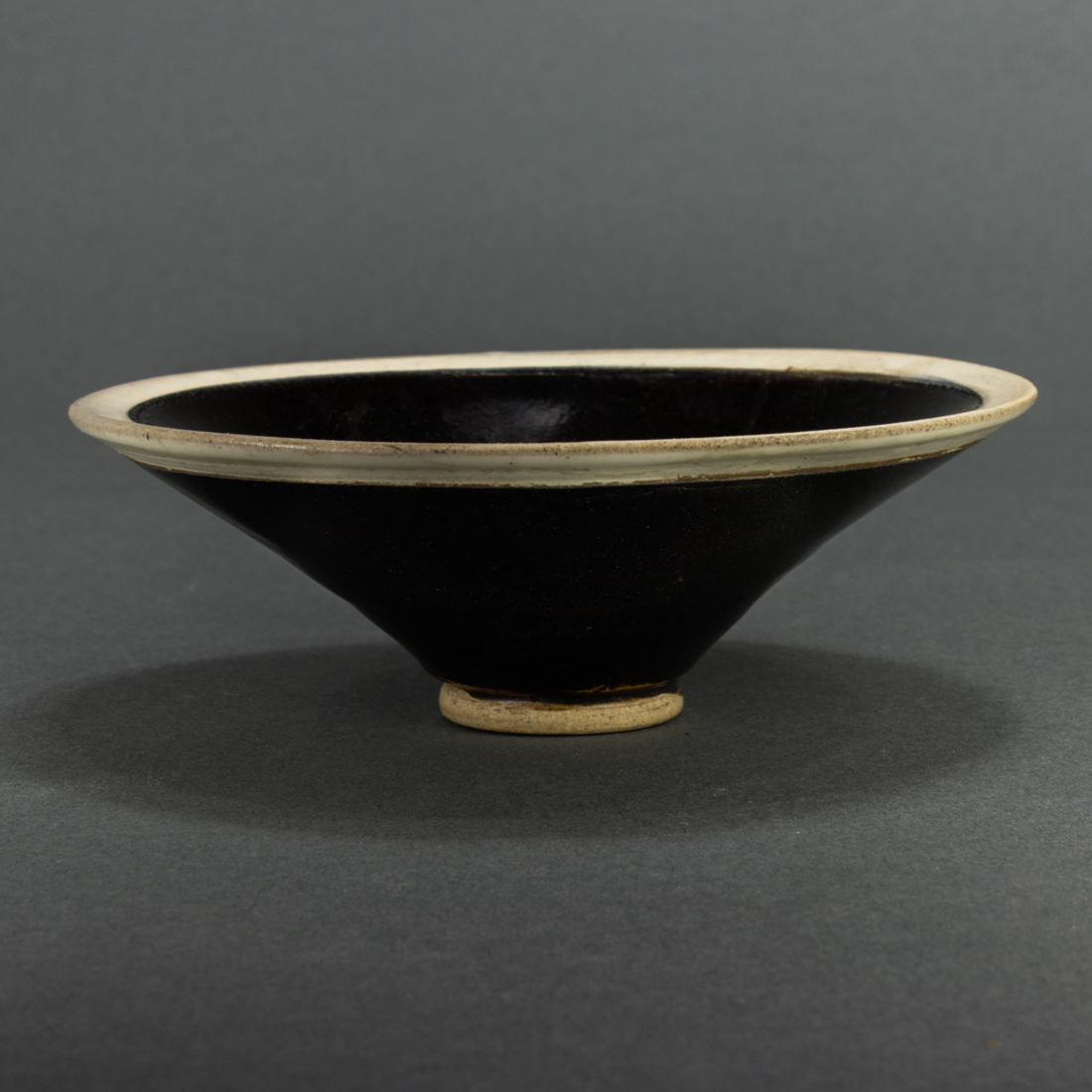 Appraisal: CHINESE BLACK GLAZED WHITE RIM CONICAL BOWL Chinese black glazed