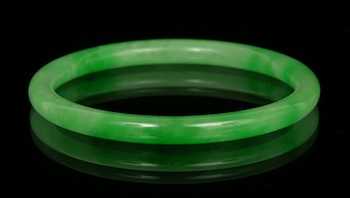 Appraisal: A Carved Jadeite Bangle Chinese Thinly carved rounded bangle bracelet