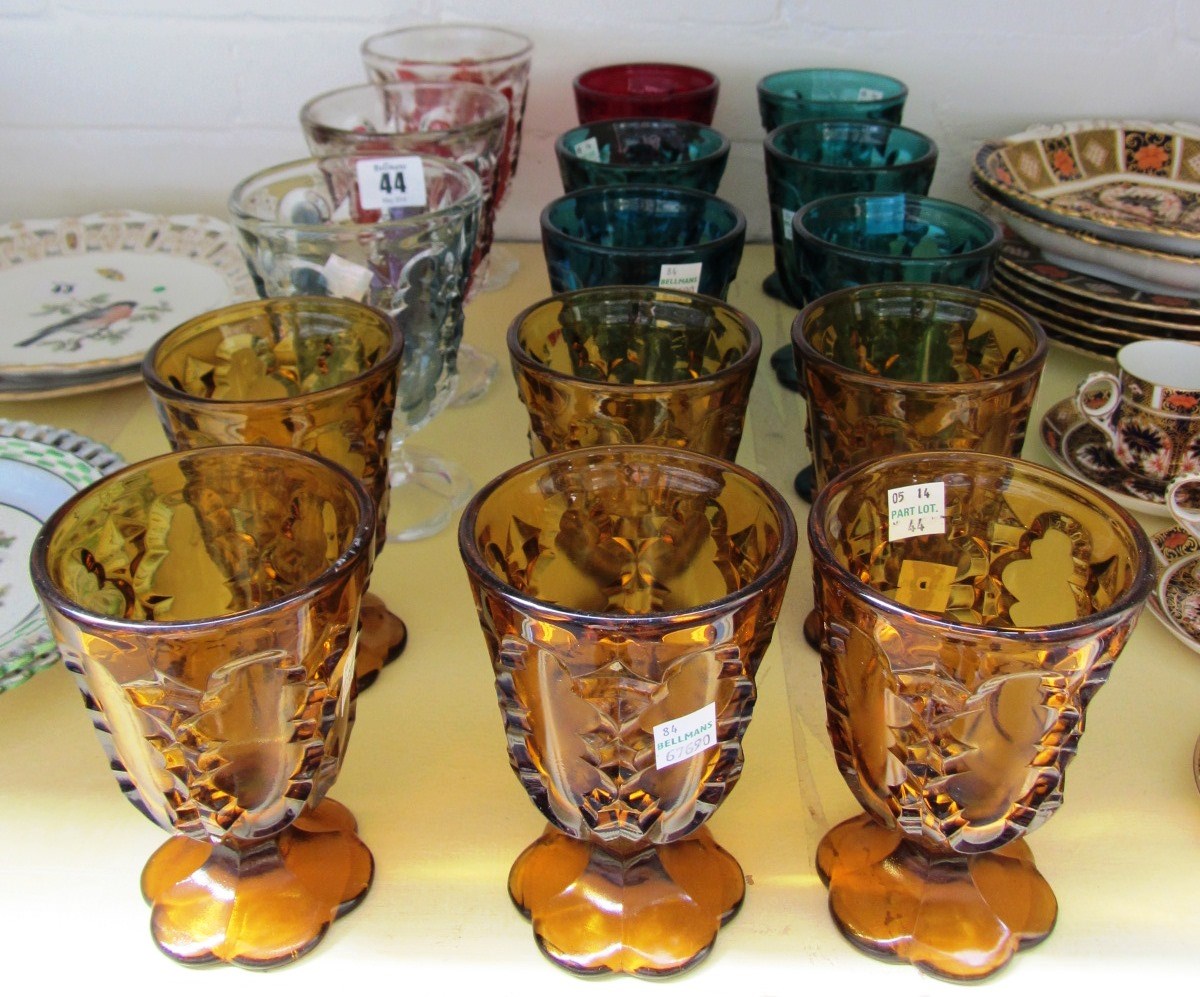 Appraisal: Twelve coloured moulded glass goblets with inset cartouche decoration on