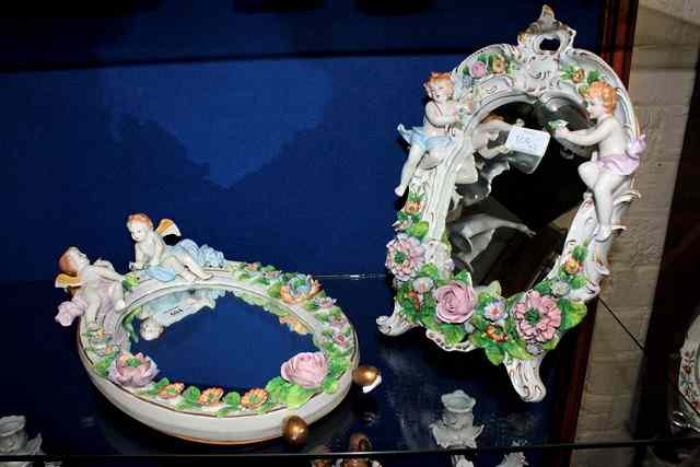 Appraisal: TWO PORCELAIN DRESSING TABLE MIRRORS with applied flowers and cherub