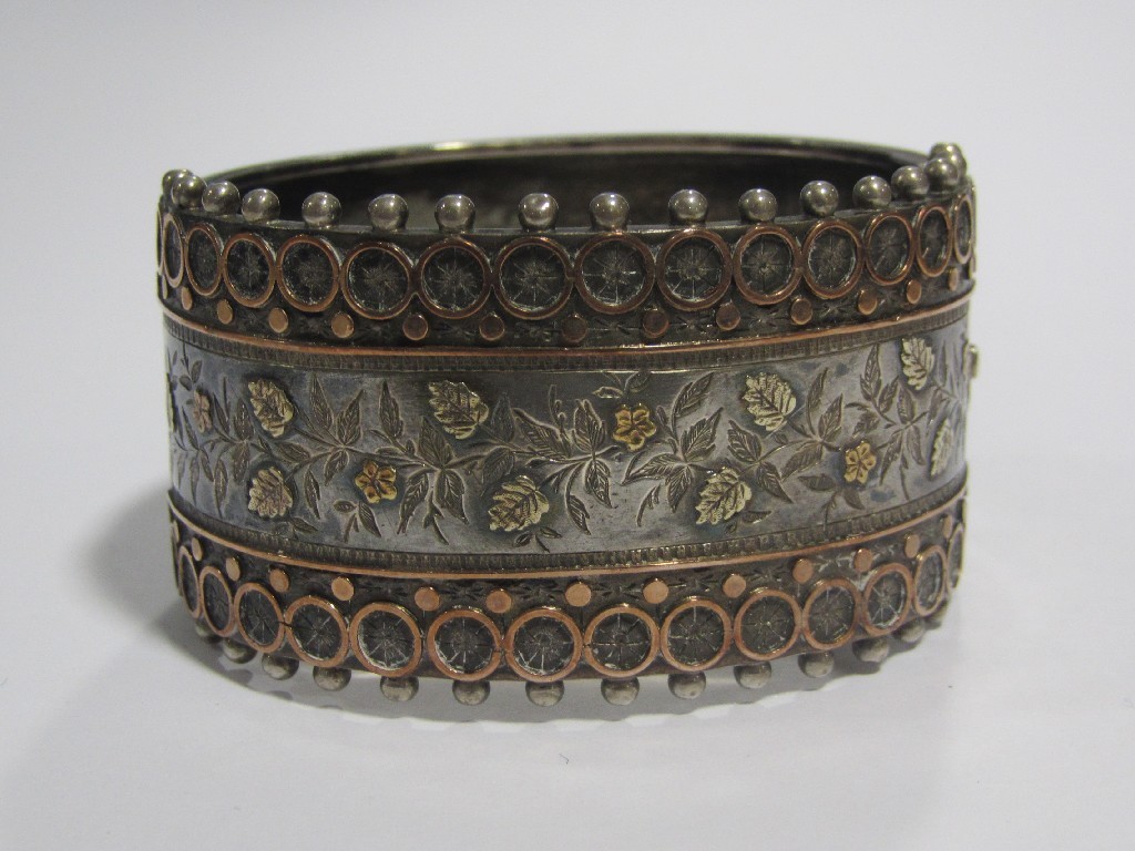 Appraisal: Victorian silver bangle with foliate engraving and gold onlay to