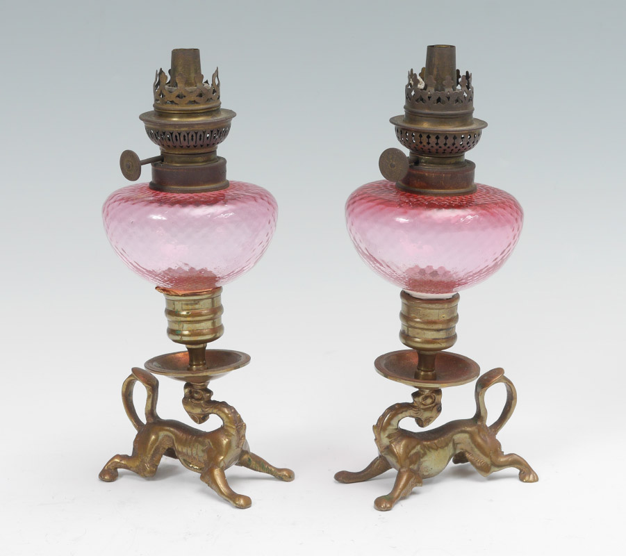 Appraisal: PAIR OF CRANBERRY GLASS AND BRASS PEG LAMPS Figural brass