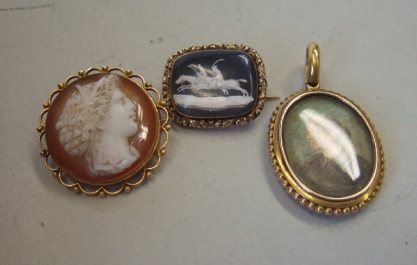 Appraisal: An oval pendant locket the front mounted with a Jasperware