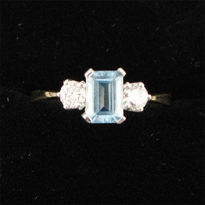 Appraisal: An aquamarine and diamond three stone ring the emerald cut