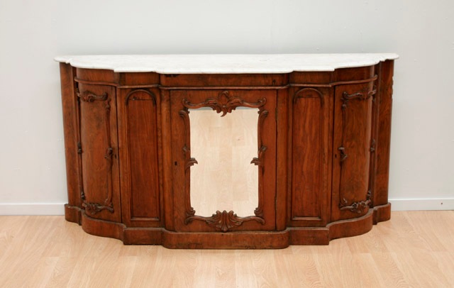 Appraisal: A Victorian walnut veneer credenza the shaped marble top aboce