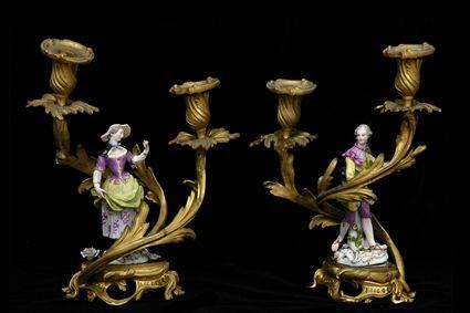 Appraisal: PAIR OF PORCELAIN FIGURE-MOUNTED GILT-BRONZE TWO-LIGHT CANDELABRA Modeled as an