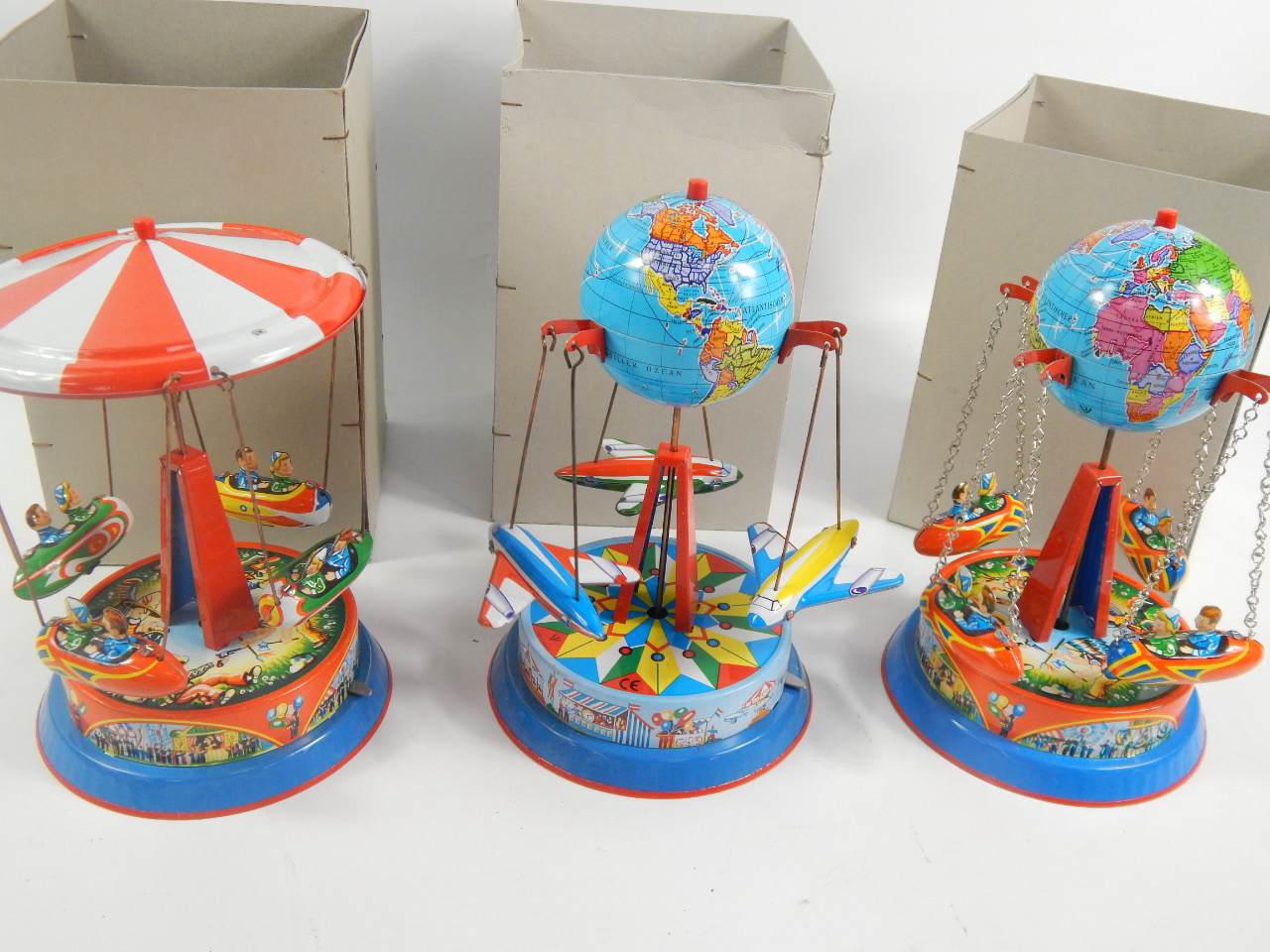 Appraisal: Three reproduction tin plate carousels two featuring globes boats and