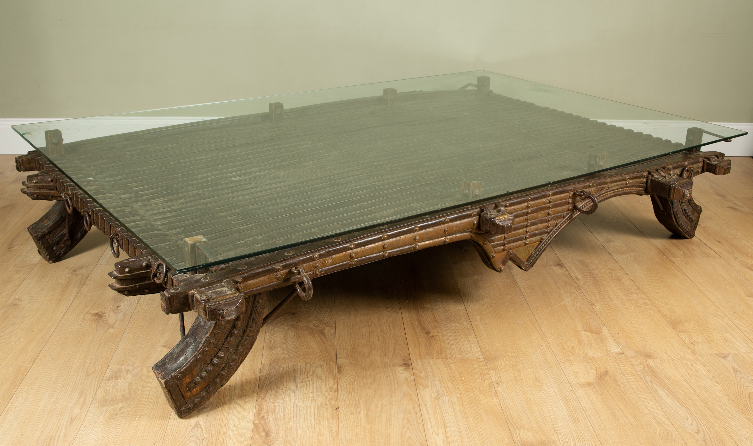 Appraisal: A large brass and iron bound wooden coffee table in