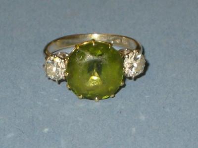 Appraisal: A PERIDOT AND DIAMOND THREE STONE RING the round cut