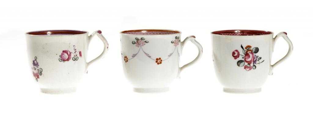 Appraisal: THREE NEW HALL CLIP HANDLED COFFEE CUPS patterns and enamelled