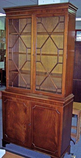 Appraisal: A mahogany bookcase enclosed by a pair of astragal glazed