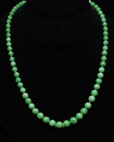 Appraisal: Natural apple green beads on silk hand knotted cord graduated