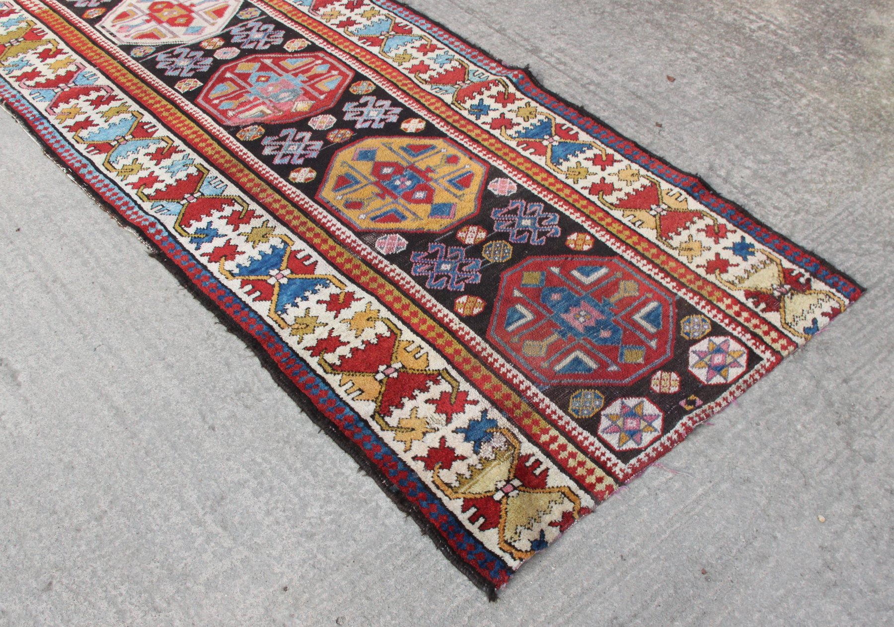 Appraisal: An Afghan runner of eight multi-coloured medallions on a dark