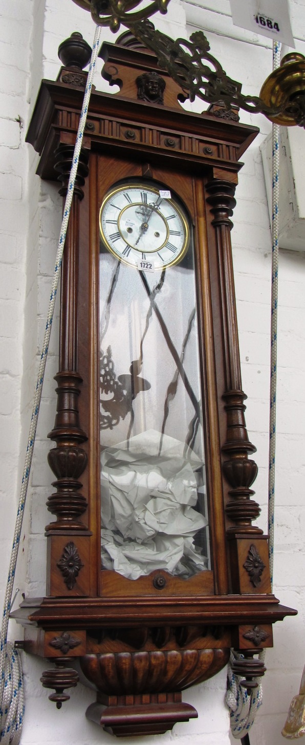 Appraisal: A walnut cased Vienna wall clock with three turned finials