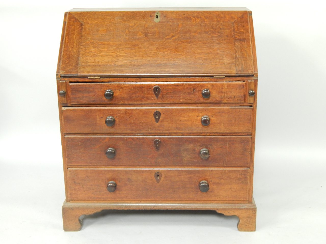 Appraisal: A George III oak bureau the fall flap opening to