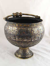 Appraisal: An Islamic brass bowl on spread foot with cast handle