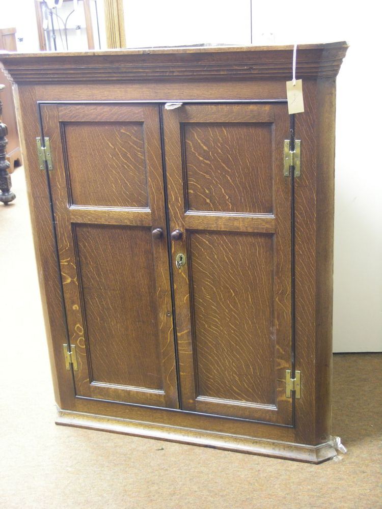 Appraisal: A late George III oak corner cupboard three shelves enclosed