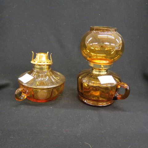 Appraisal: Amber Glass Oil Lamps both with finger rings one is