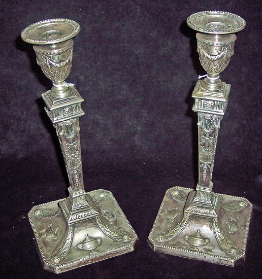 Appraisal: A pair of candlesticks of Adam design embossed swags urns