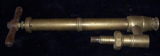 Appraisal: A brass stirrup pump with turned wood handle cm high