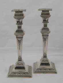 Appraisal: A pair of silver candlesticks the square tapering columns with